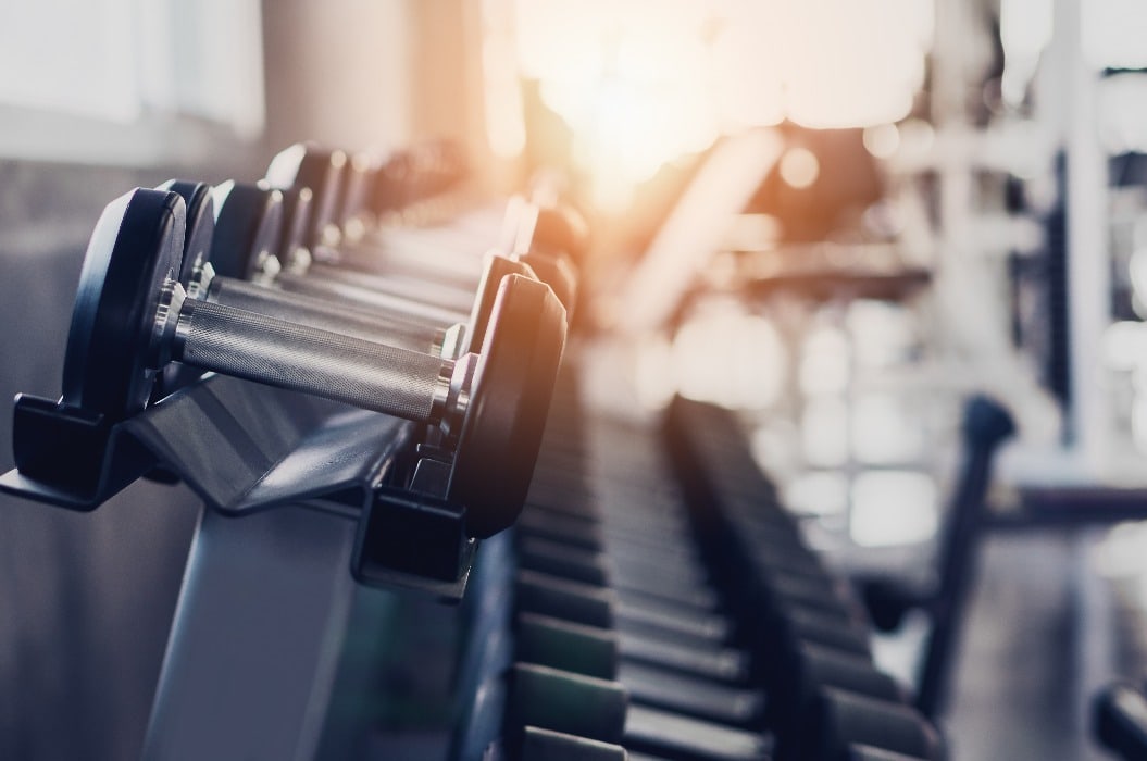 gym interior background of dumbbells on rack in fitness and workout room