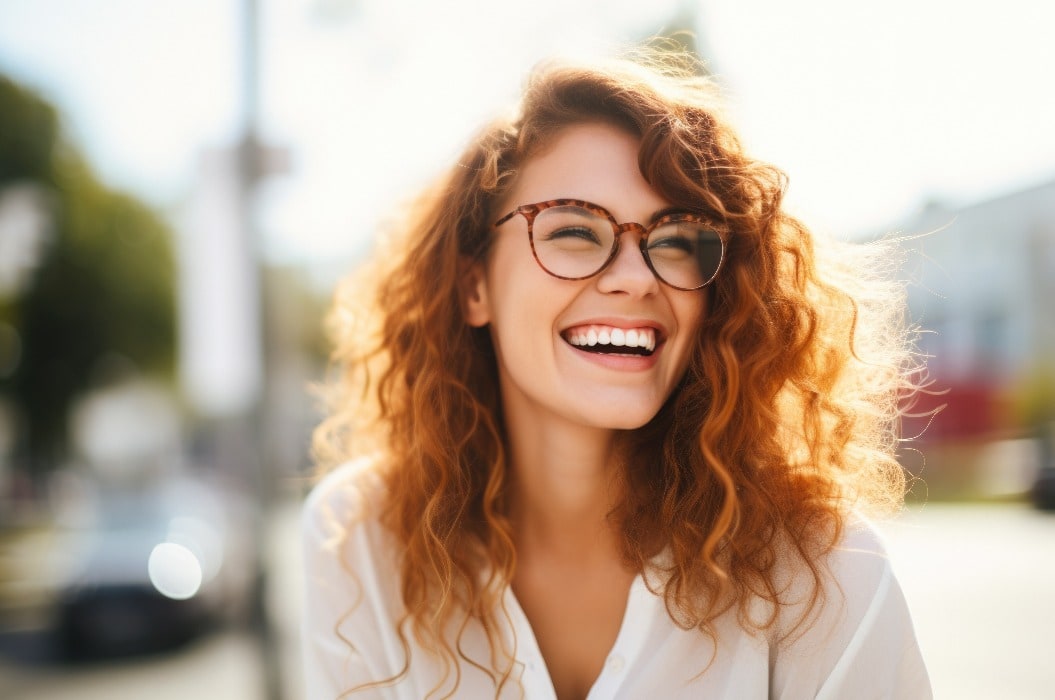 Portrait of happy young woman wearing glasses outdoors