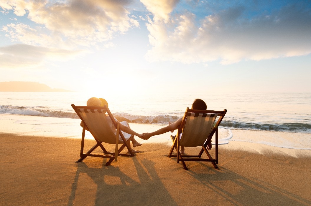 Young couple sunbathing on beach chair