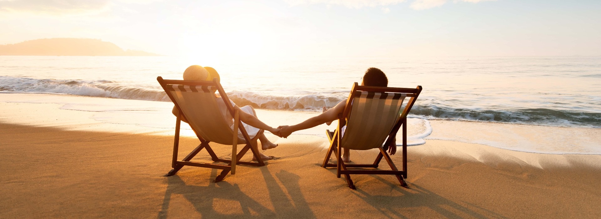 Junges Paar sonnt sich am Strand in Liegestühlen